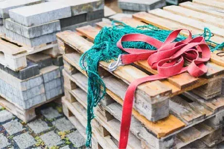 Pallets with red and green straps on top.