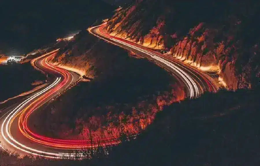 Estrada noturna com marcas de velocidade vermelhas e laranjas