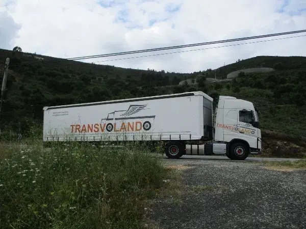 Camion rotulado de Trasnvolando aparcado sobre fondo montañoso